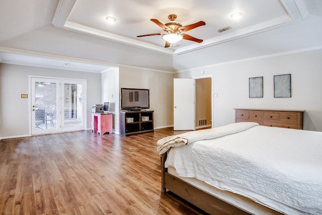 bedroom featuring ornamental molding, access to outside, hardwood / wood-style floors, and a tray ceiling