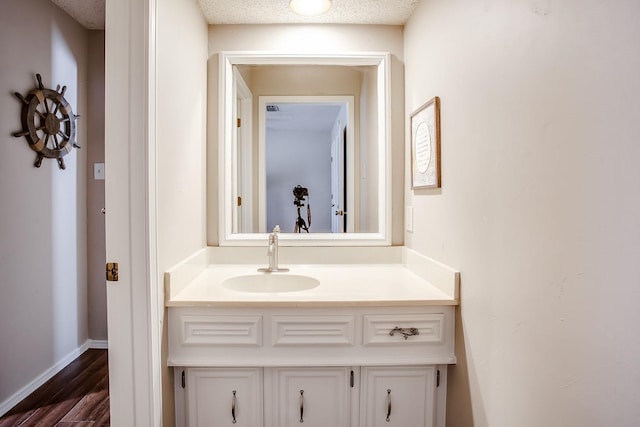 bathroom with vanity, hardwood / wood-style flooring, and a textured ceiling