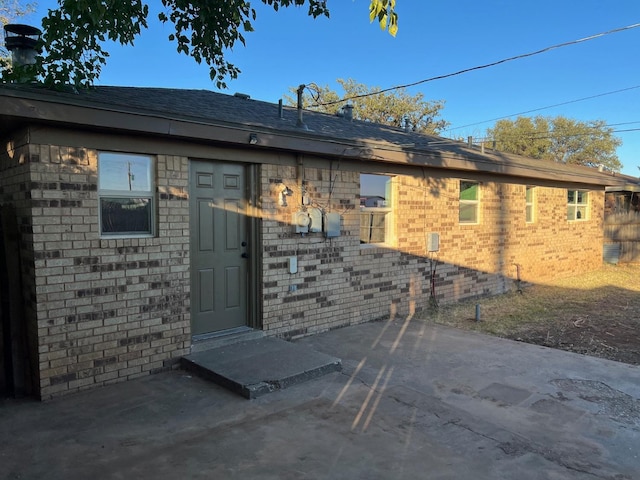 view of exterior entry with a patio area