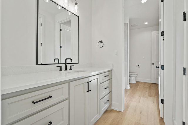 bathroom featuring vanity, toilet, and hardwood / wood-style floors