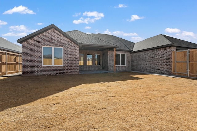 rear view of property featuring a yard and a patio area