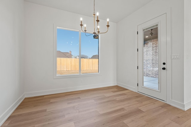 unfurnished dining area featuring a chandelier and light hardwood / wood-style floors