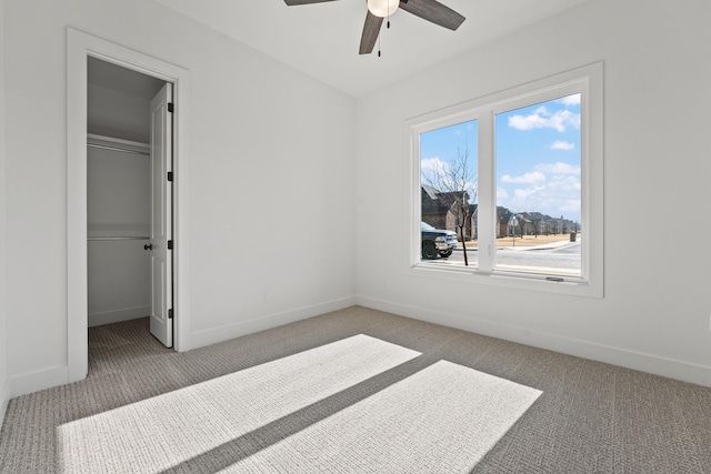 bedroom with a walk in closet, carpet flooring, ceiling fan, and a closet