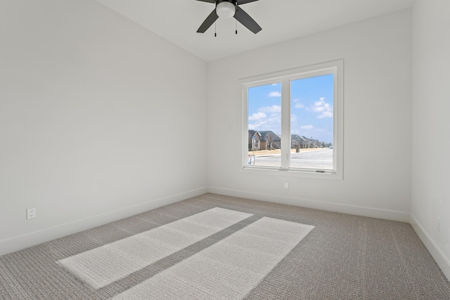 empty room featuring ceiling fan and carpet