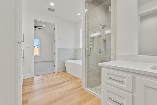 bathroom featuring hardwood / wood-style flooring, vanity, lofted ceiling, and shower with separate bathtub