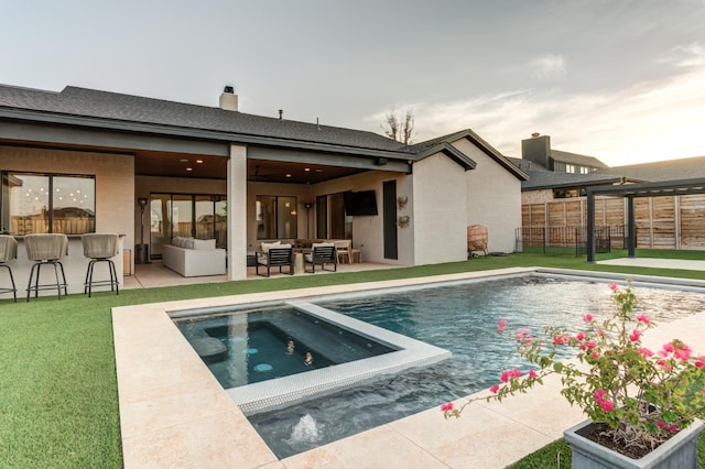 view of swimming pool featuring an in ground hot tub, a yard, a patio area, and a bar