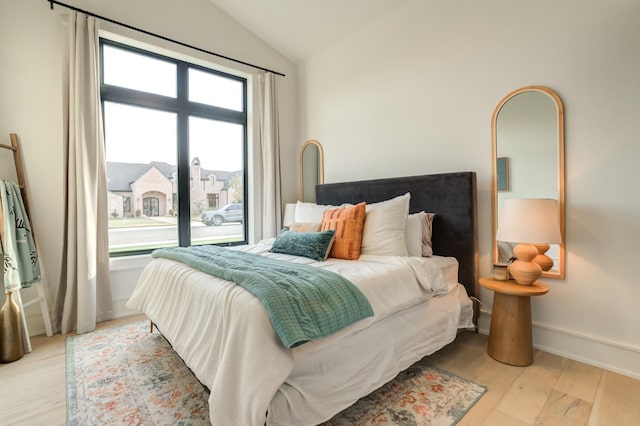 bedroom with lofted ceiling and light hardwood / wood-style flooring