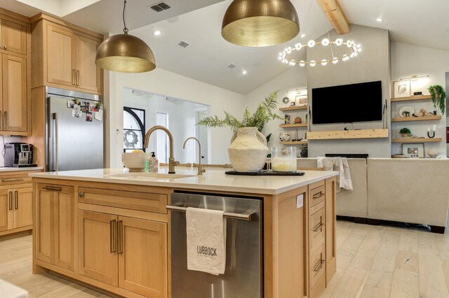 kitchen featuring sink, light hardwood / wood-style flooring, appliances with stainless steel finishes, a kitchen island with sink, and decorative light fixtures