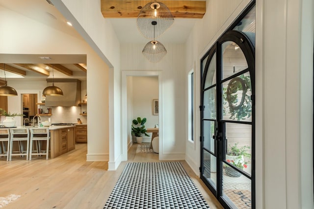 interior space featuring beamed ceiling and light wood-type flooring