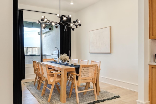 dining space with a chandelier and light hardwood / wood-style flooring