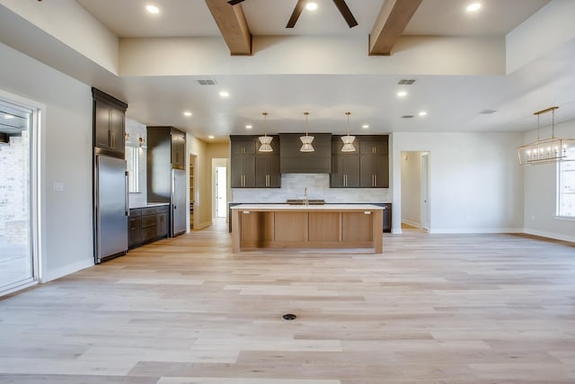 kitchen with built in refrigerator, tasteful backsplash, beam ceiling, and a sink