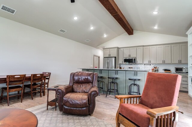 living room featuring high vaulted ceiling, beam ceiling, and light hardwood / wood-style floors