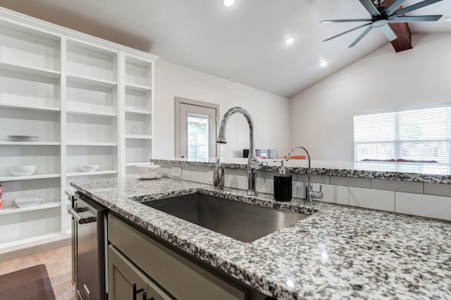 kitchen with a wealth of natural light, sink, stainless steel dishwasher, and light stone counters