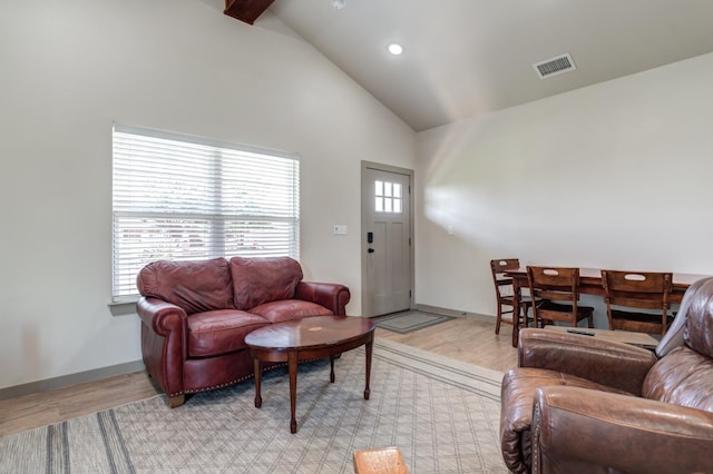 living room with beam ceiling, high vaulted ceiling, and light wood-type flooring