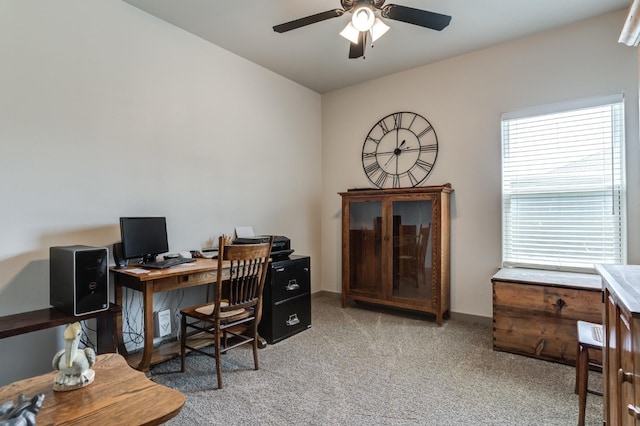 carpeted home office featuring ceiling fan