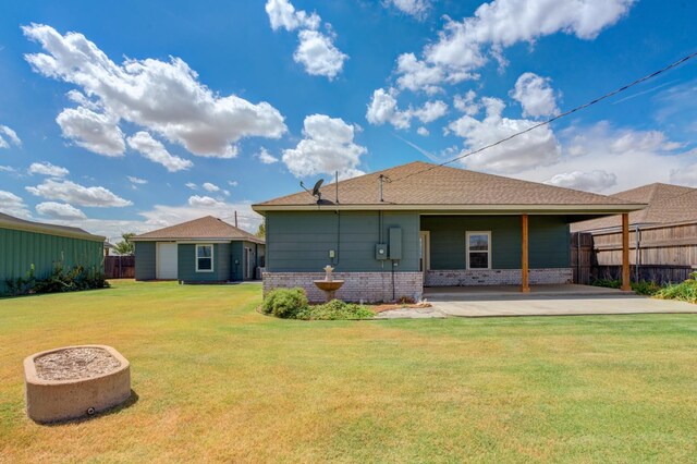 back of property with a patio area and a lawn