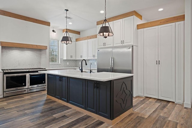 kitchen with stainless steel appliances, a sink, visible vents, and white cabinets