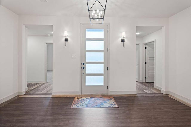 entryway with an inviting chandelier, baseboards, and wood finished floors