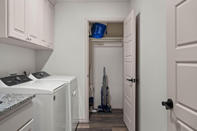 laundry room featuring dark wood-style floors, washing machine and dryer, cabinet space, and baseboards