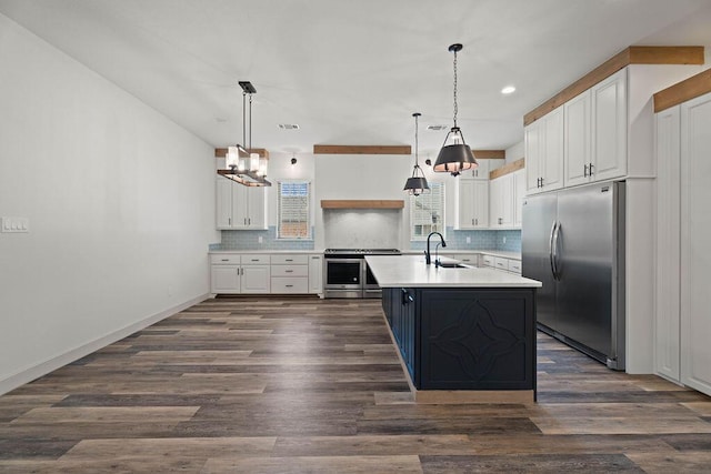 kitchen featuring dark wood-style flooring, stainless steel appliances, light countertops, backsplash, and white cabinetry