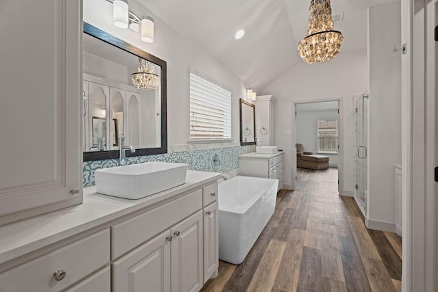 full bath featuring a wealth of natural light, a shower stall, a chandelier, and a sink