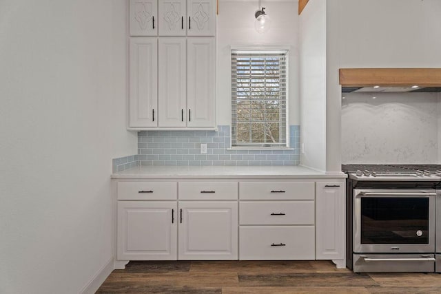 kitchen with tasteful backsplash, dark wood-style flooring, stainless steel range with gas cooktop, and white cabinets