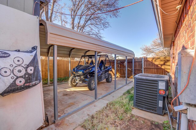 6910 Freeport Ave, Lubbock, TX 79424 - view of patio / terrace featuring central AC unit, fence, and a detached carport