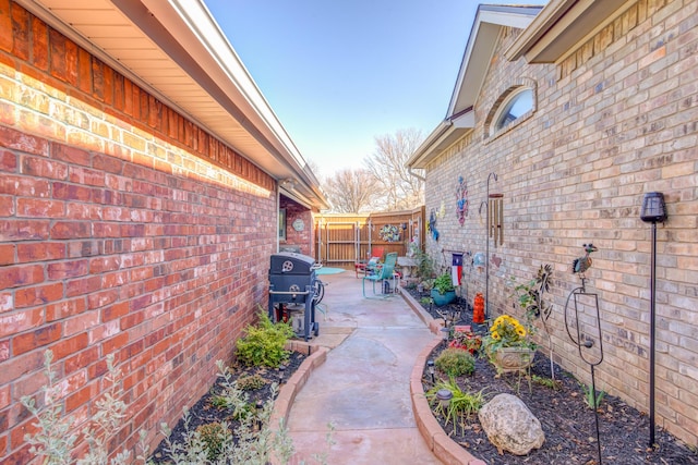 6910 Freeport Ave, Lubbock, TX 79424 - view of property exterior featuring brick siding, a patio, and fence