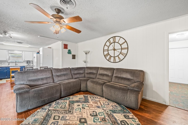 4411 58th St, Lubbock, TX 79414 - living room featuring wood finished floors, a ceiling fan, and a textured ceiling
