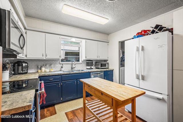 4411 58th St, Lubbock, TX 79414 - kitchen with appliances with stainless steel finishes, blue cabinets, light countertops, backsplash, and a textured ceiling