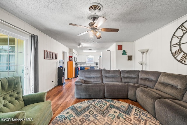4411 58th St, Lubbock, TX 79414 - living room with wood finished floors, a ceiling fan, a textured ceiling, and ornamental molding