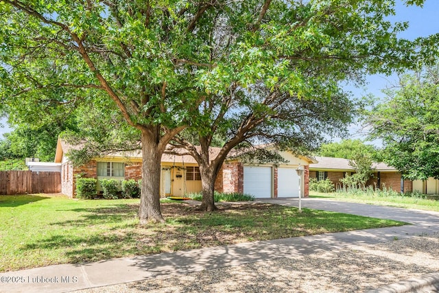 4411 58th St, Lubbock, TX 79414 - view of front facade featuring brick siding, asphalt driveway, and an attached garage
