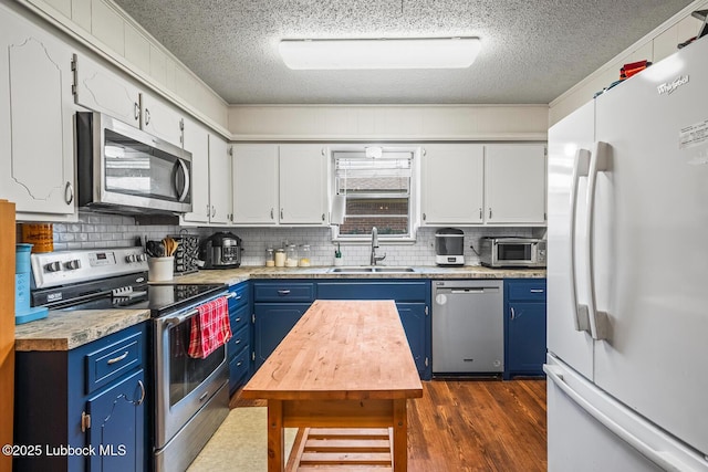 4411 58th St, Lubbock, TX 79414 - kitchen with appliances with stainless steel finishes, blue cabinetry, a textured ceiling, decorative backsplash, and dark wood finished floors