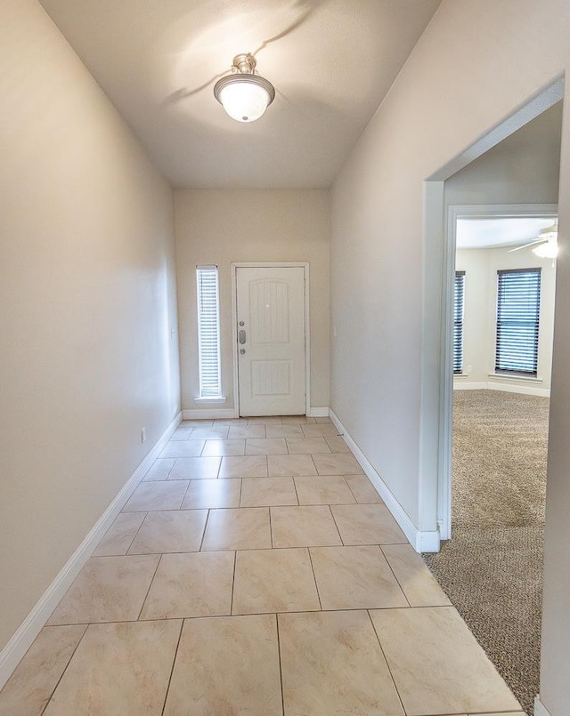 interior space with light tile patterned floors and ceiling fan