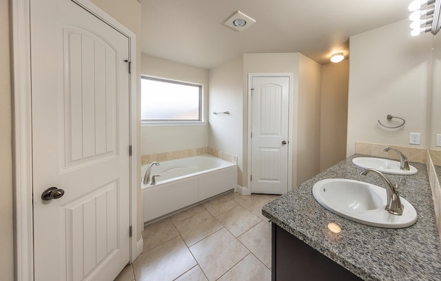 bathroom featuring tile patterned floors, a bathing tub, and vanity