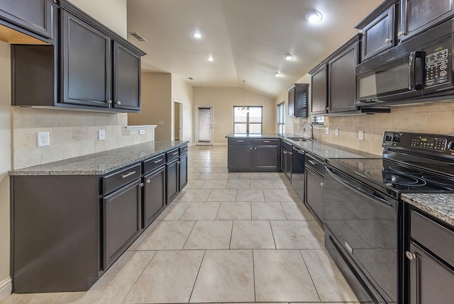 kitchen featuring sink, light tile patterned floors, black appliances, vaulted ceiling, and dark stone counters