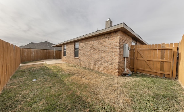 view of side of property with a yard and a patio area