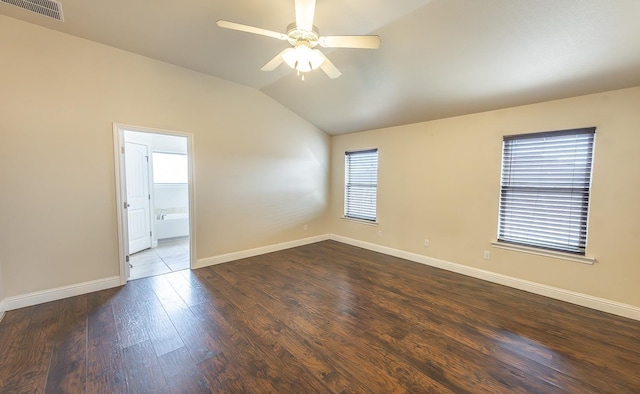 unfurnished room with dark wood-type flooring, plenty of natural light, and vaulted ceiling