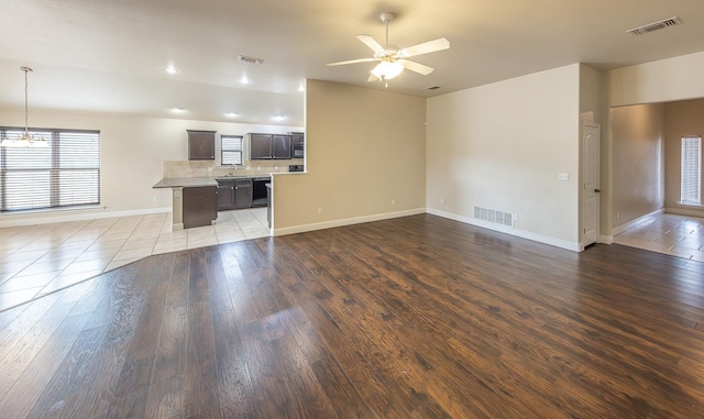 unfurnished living room featuring ceiling fan, sink, and light hardwood / wood-style flooring