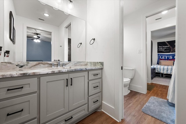 bathroom with vanity, ceiling fan, hardwood / wood-style flooring, and toilet