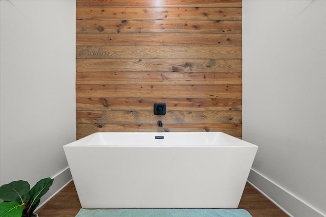 bathroom featuring a tub to relax in and wood-type flooring