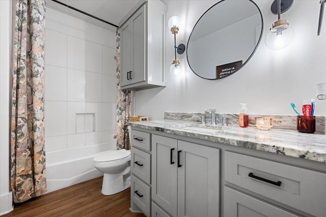 full bathroom featuring wood-type flooring, vanity, shower / bath combo with shower curtain, and toilet