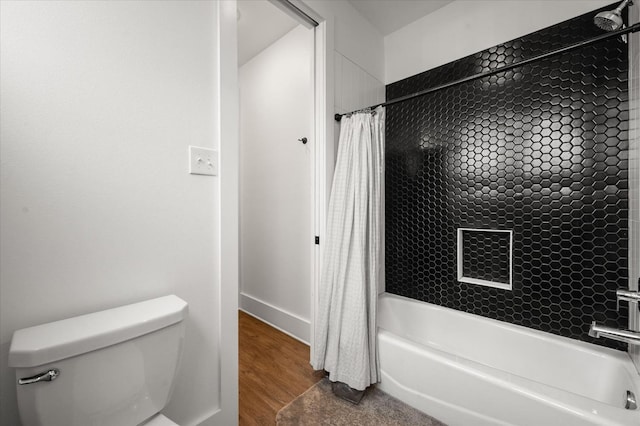 bathroom with hardwood / wood-style floors, toilet, and shower / bath combo with shower curtain