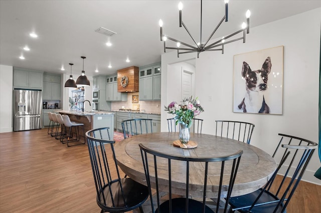 dining room with sink and light hardwood / wood-style flooring