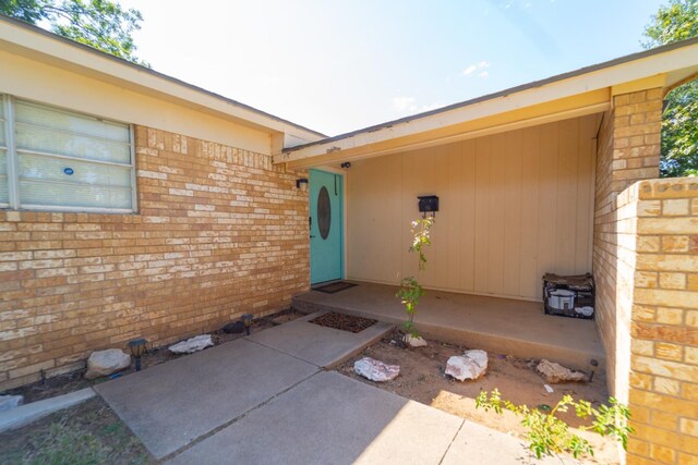 doorway to property featuring brick siding