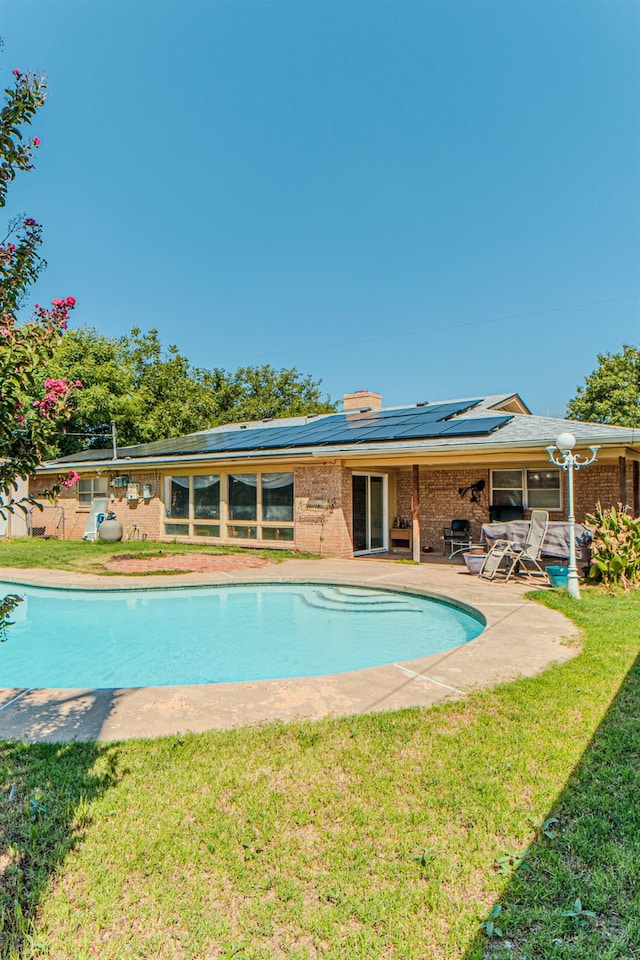 view of swimming pool featuring a lawn and a patio