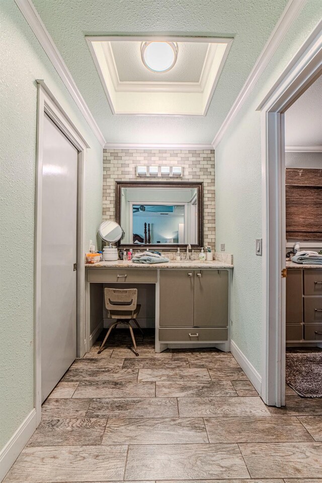 bathroom with crown molding, vanity, a tray ceiling, and a textured ceiling