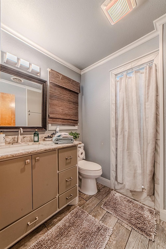 bathroom featuring crown molding, vanity, a textured ceiling, curtained shower, and toilet