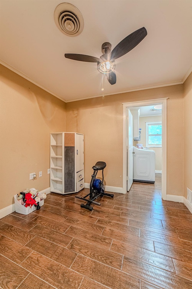 exercise area featuring ceiling fan, ornamental molding, wood-type flooring, and washer / dryer