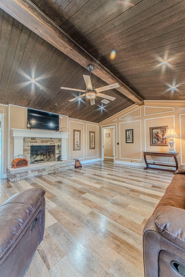 living room featuring wood ceiling, vaulted ceiling with beams, a fireplace, and light wood-type flooring